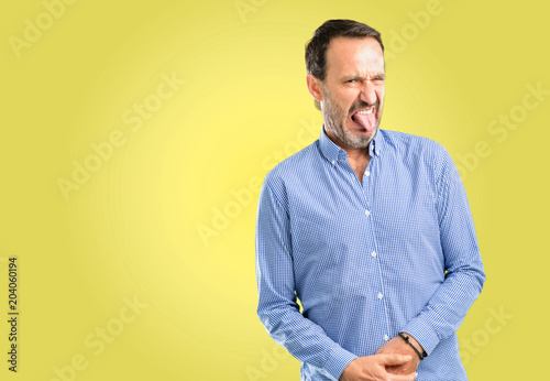 Handsome middle age man feeling disgusted with tongue out © Krakenimages.com