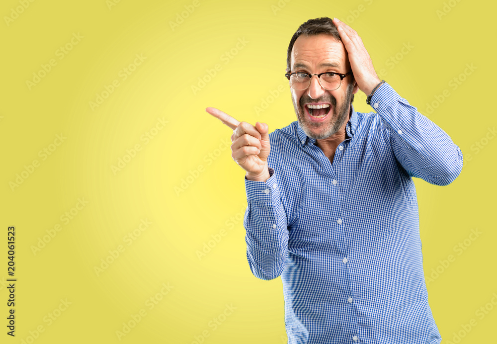 Handsome middle age man pointing away side with his finger Handsome middle age man pointing away side with his finger