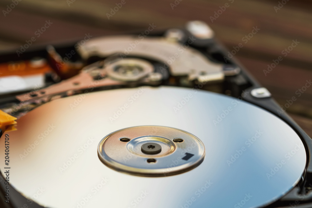 Open computer hard disk drive (HDD) with spindle and plate. Closeup, selective focus Open computer hard disk drive (HDD) with spindle and plate. Closeup, selective focus