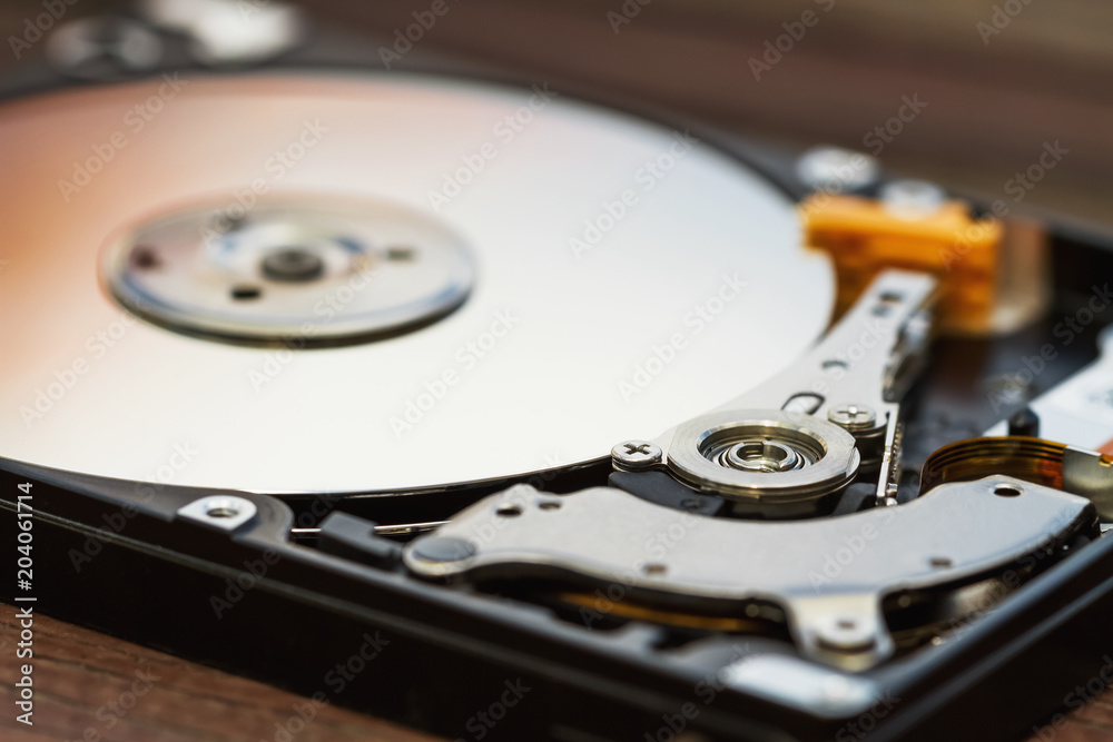 Open computer hard disk drive (HDD) with spindle and plate. Closeup, selective focus Open computer hard disk drive (HDD) with spindle and plate. Closeup, selective focus