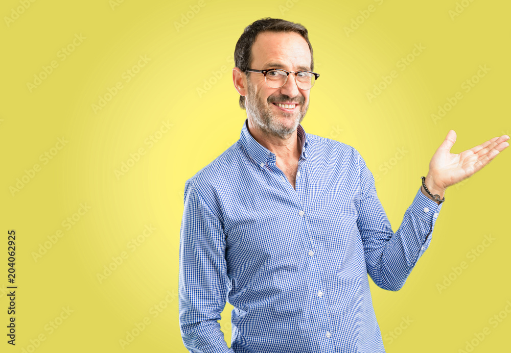 Handsome middle age man holding something in his empty hand Handsome middle age man holding something in his empty hand