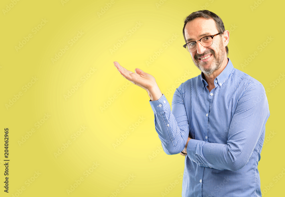 Handsome middle age man holding something in his empty hand