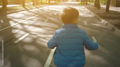 Little boy on a bicycle at asphalt road. Cute boy learning to ride bicycle on a bicycle track. photo