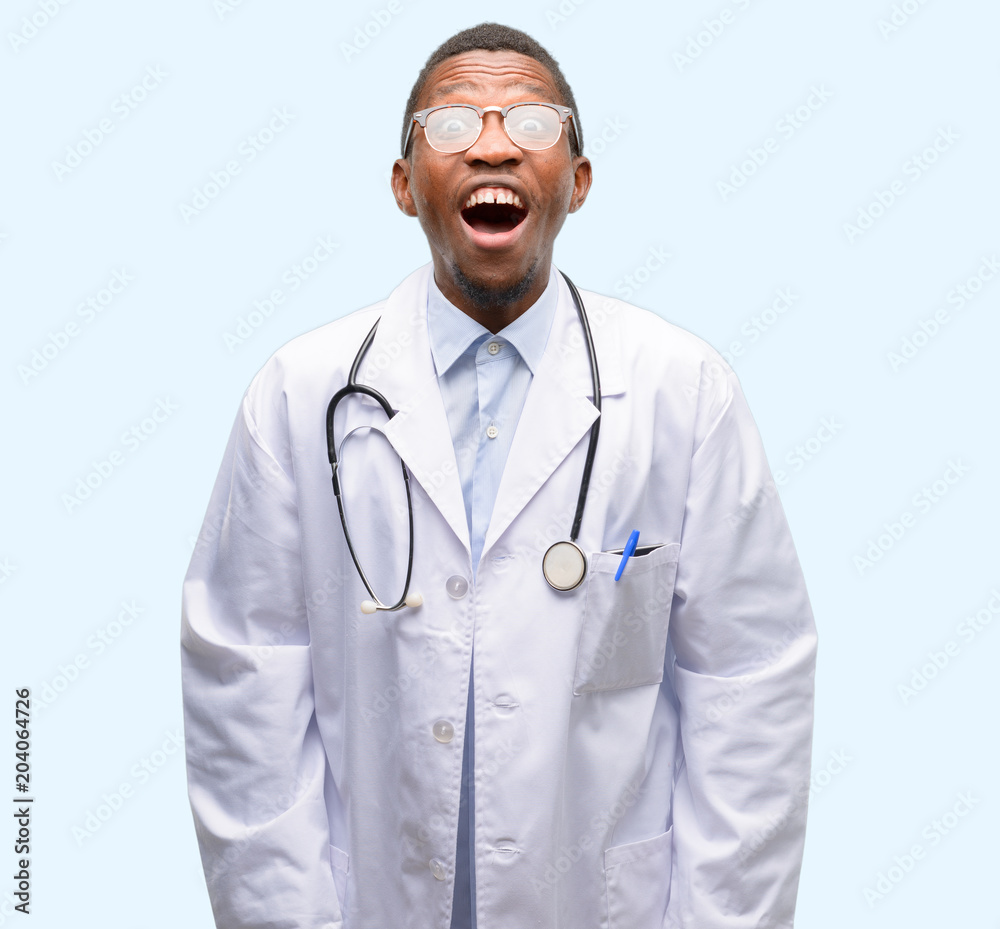 Young black doctor, medical professional stressful, terrified in panic, shouting exasperated and frustrated. Unpleasant gesture. Annoying work drives me crazy Young black doctor, medical professional stressful, terrified in panic, shouting exasperated and frustrated. Unpleasant gesture. Annoying work drives me crazy