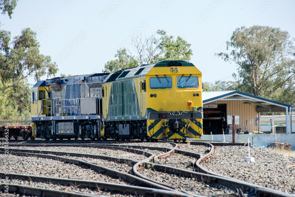 Fototapeta premium Yellow train approaching on train tracks