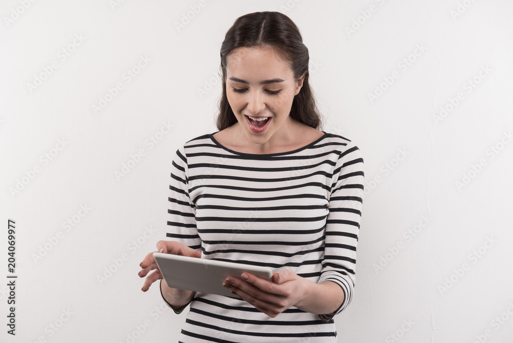 So excited. Emotional young woman laughing while using a tablet So excited. Emotional young woman laughing while using a tablet