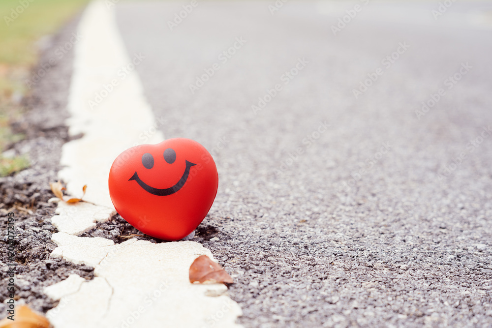 Fototapeta premium Smile red heart beside road,health, medicine and charity concept.