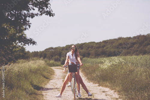 femal twin having fun on a bicycle