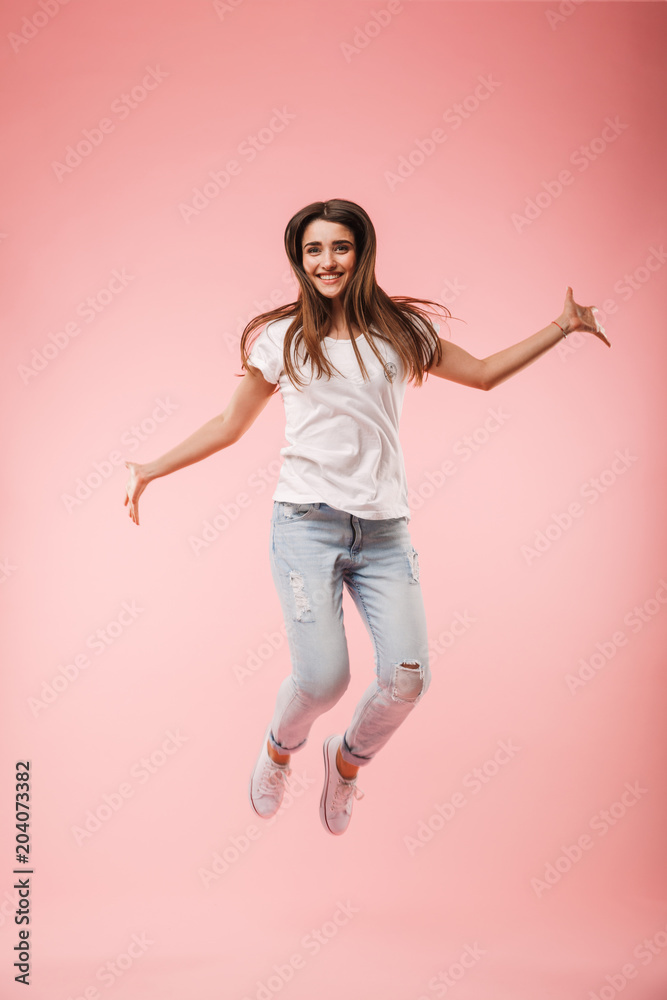 Full length of an excited young woman jumping Full length of an excited young woman jumping
