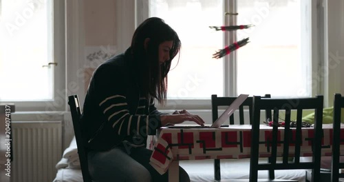 Girl working from home on her laptop, checking emails browsing the internet. Candid authentic 4K clip of young woman studying on her computer4 photo