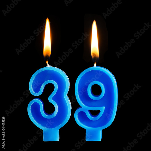 Burning birthday candles in the form of 39 thirty nine for cake isolated on black background.