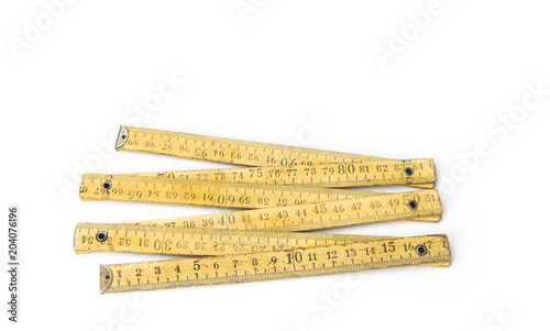 Old yellow construction folding meter on the white background
