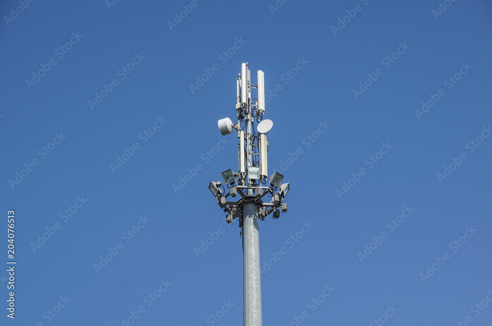 Mobile phone communication antenna tower with satellite dish on blue sky background, Telecommunication tower Mobile phone communication antenna tower with satellite dish on blue sky background, Telecommunication tower
