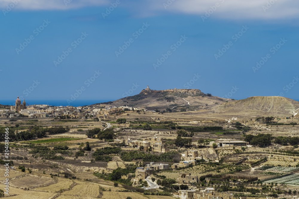 Gozo, Malta panoramic island day view. Landscape view of countryside with traditional limestone buildings seen from Citadel acropolis in Victoria town.