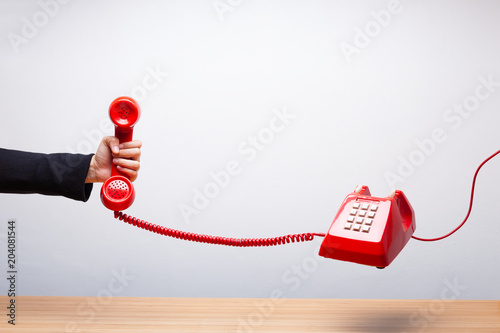 Business woman holding the red phone