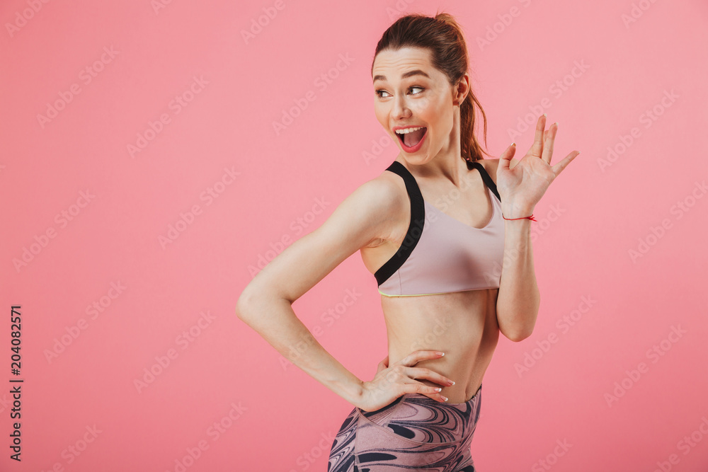 Sportswoman with arm on hip while looking and waving back Sportswoman with arm on hip while looking and waving back