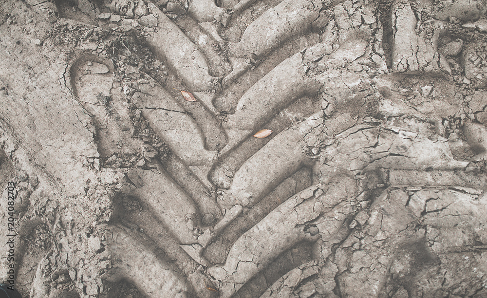 Imprint of the jeep tire on the gray earth. Tractor wheel on the ground. Tire protector close-up. Gray background. SUV. Imprint of the jeep tire on the gray earth. Tractor wheel on the ground. Tire protector close-up. Gray background. SUV.