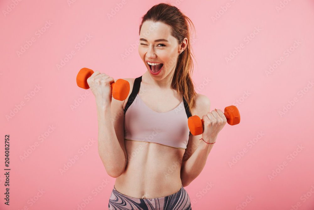 Happy screaming sportswoman doing exercise with dumbbells Happy screaming sportswoman doing exercise with dumbbells
