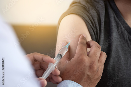 Medicine and health care concept Doctor giving patient vaccine insulin or vaccination photo