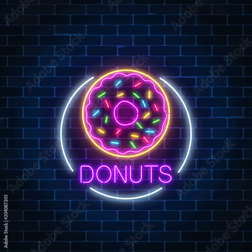 Neon glowing sign of donuts in circle frame on a dark brick wall background. Fastfood light billboard symbol.