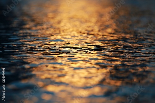 Shimmering Golden Orange Blue and Black Water Ripples Backlit by Sunset