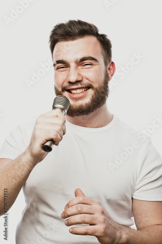 lifestyle and people concept: young man singing with microphone