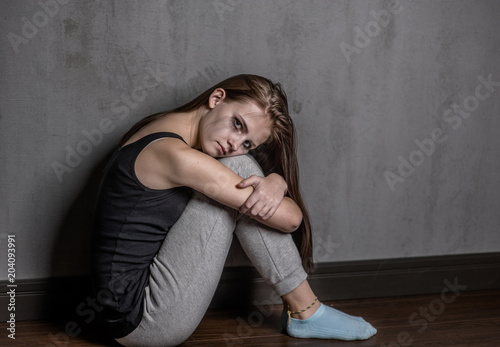 sad teen girl hug her knee and cry