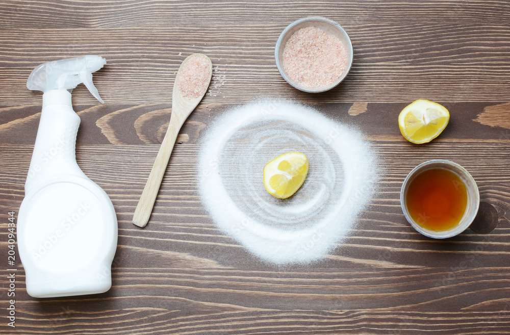 Eco friendly natural cleaners baking soda, salt, lemon and vinegar on a wooden background. Eco friendly natural cleaners baking soda, salt, lemon and vinegar on a wooden background.