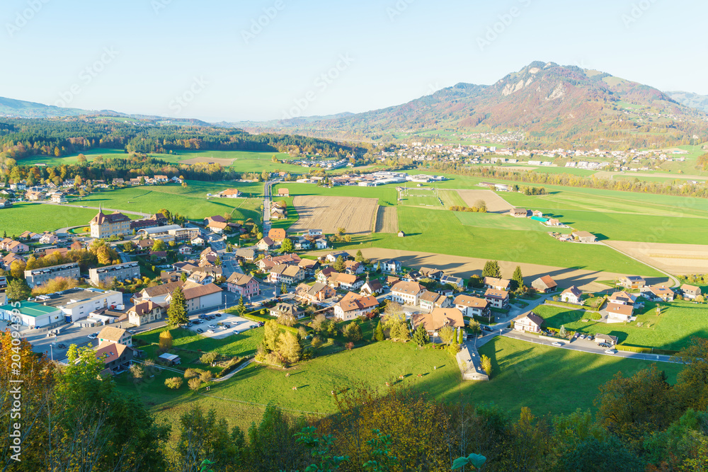 Aerial view of a beautiful landscape with traditional houses, green meadows, Gruyeres, Switzerland