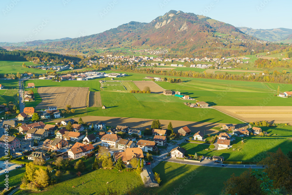 Aerial view of a beautiful landscape with traditional houses, green meadows, Gruyeres, Switzerland