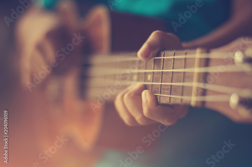 Hands playing acoustic guitar ukulele  photo