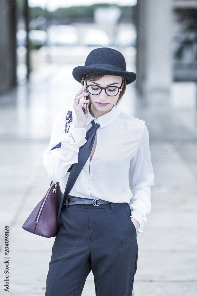 Manager con camicia bianca, cappello nero, cravatta e borsa è impegnata in  una telefonata di lavoro - sfondo ambiente business Stock Photo | Adobe  Stock