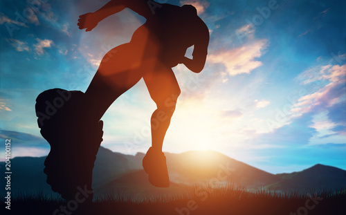 Man running towards the sunset in the mountains photo