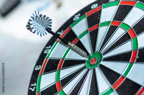 Dart arrow hitting in the target center of dartboard using as background Target business, achieve and victory,success concept.