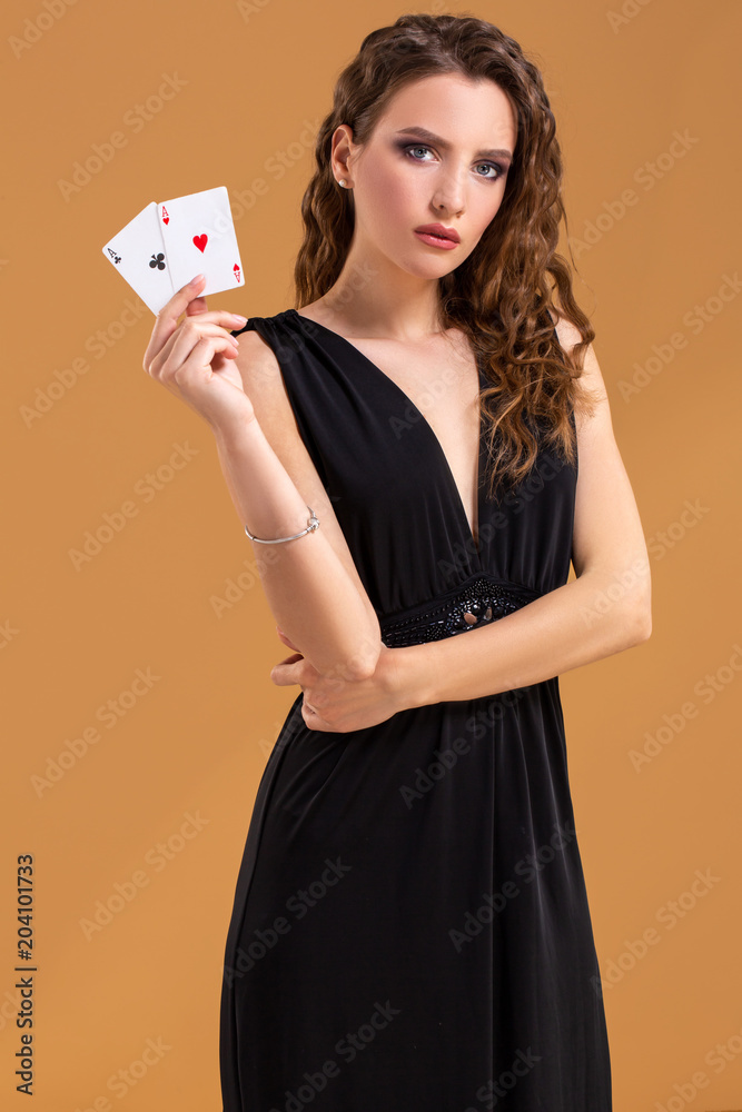 Beautiful brown-haired woman holding two aces as a sign for poker game, gambling and casino Beautiful brown-haired woman holding two aces as a sign for poker game, gambling and casino