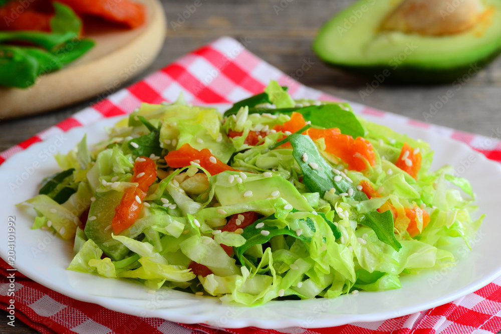 Simple vegetarian avocado coleslaw. Home coleslaw salad with fresh avocado slices, dried apricots, green arugula and sesame seeds on a plate. Healthy food diet. Clean eating recipe for weight loss