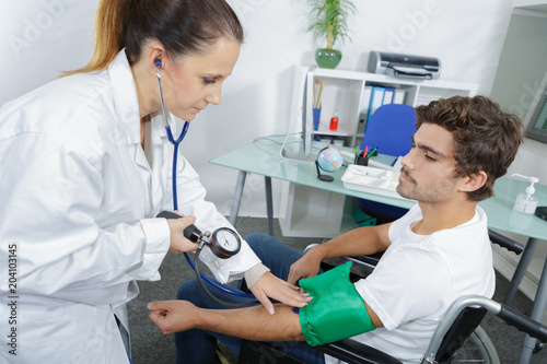 doctor measures the blood pressure of a patient young man