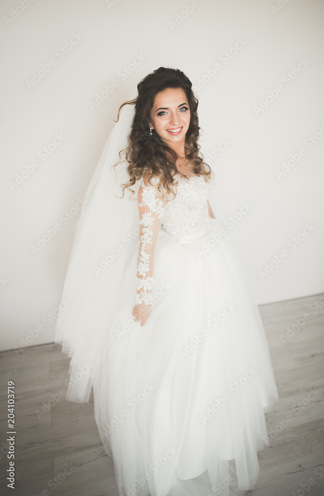 Luxury bride in white dress posing while preparing for the wedding ceremony Luxury bride in white dress posing while preparing for the wedding ceremony