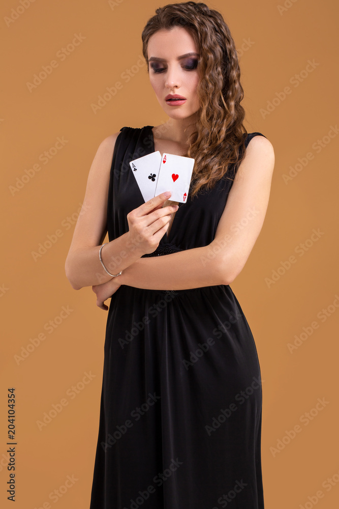 Beautiful brown-haired woman holding two aces as a sign for poker game, gambling and casino Beautiful brown-haired woman holding two aces as a sign for poker game, gambling and casino