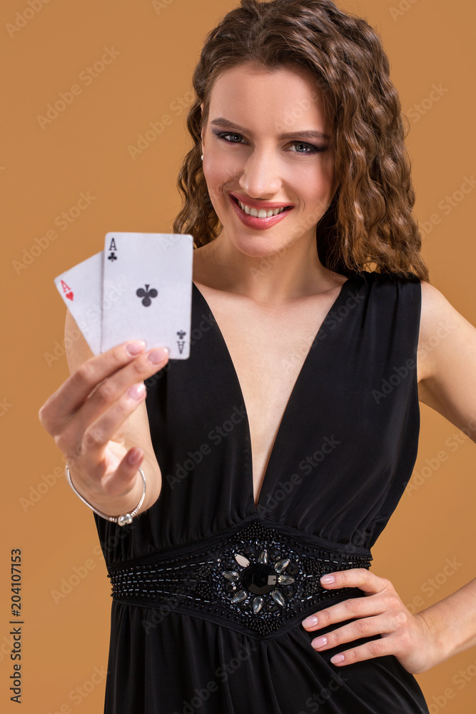 Beautiful brown-haired woman holding two aces as a sign for poker game, gambling and casino Beautiful brown-haired woman holding two aces as a sign for poker game, gambling and casino