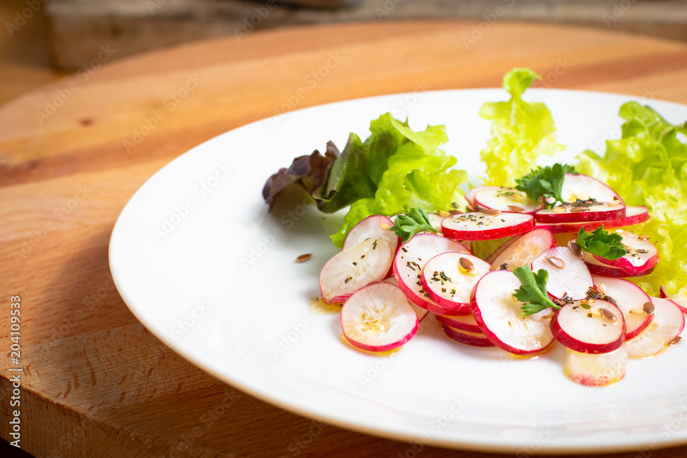 Healthy food organic slices radish salad in white plate on wood board Healthy food organic slices radish salad in white plate on wood board