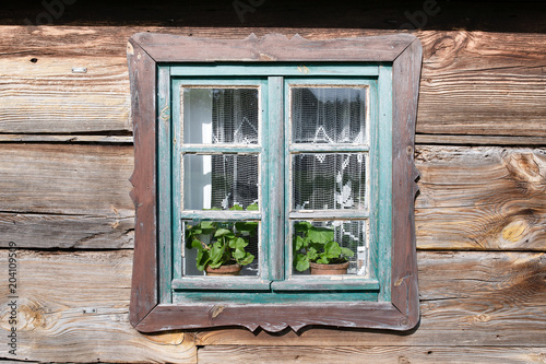 Old traditional windows in wooden vintage farm houses. Polish countryside