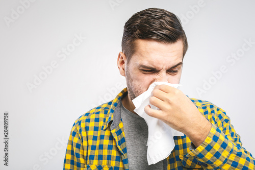 Studio picture with a young man with handkerchief. Sick guy isolated has runny nose. man makes a cure for the common cold