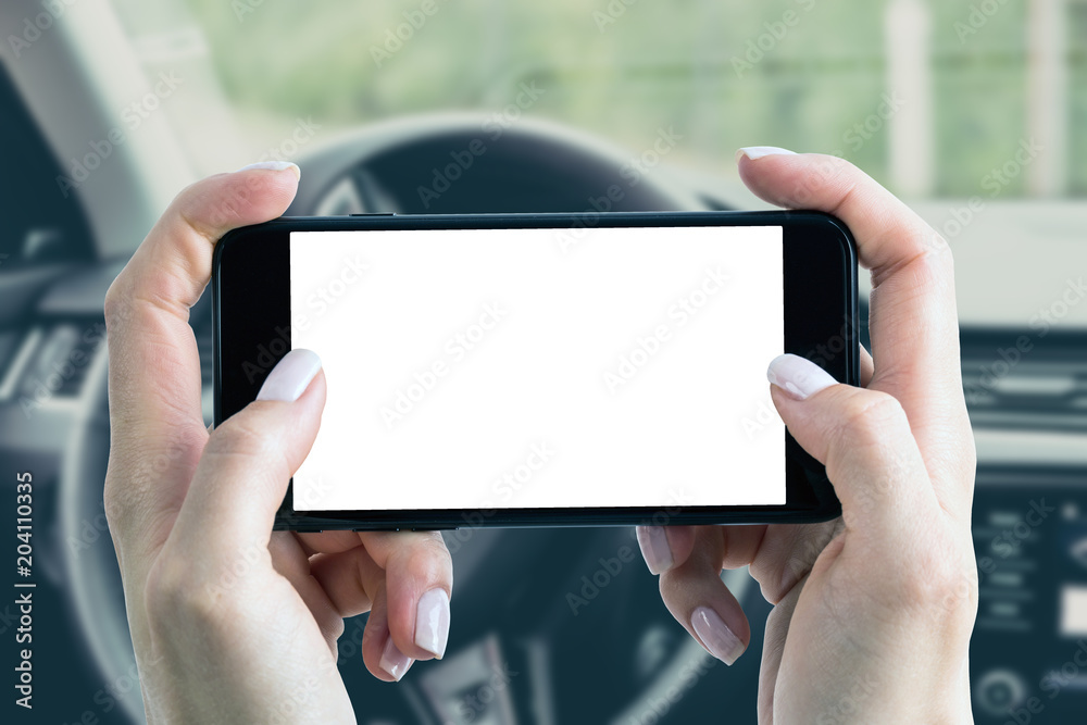 Using a smartphone in the car. Blank smartphone screen with a copy space held in the hands of a woman.
