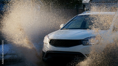 The car is driving at high speed in a puddle