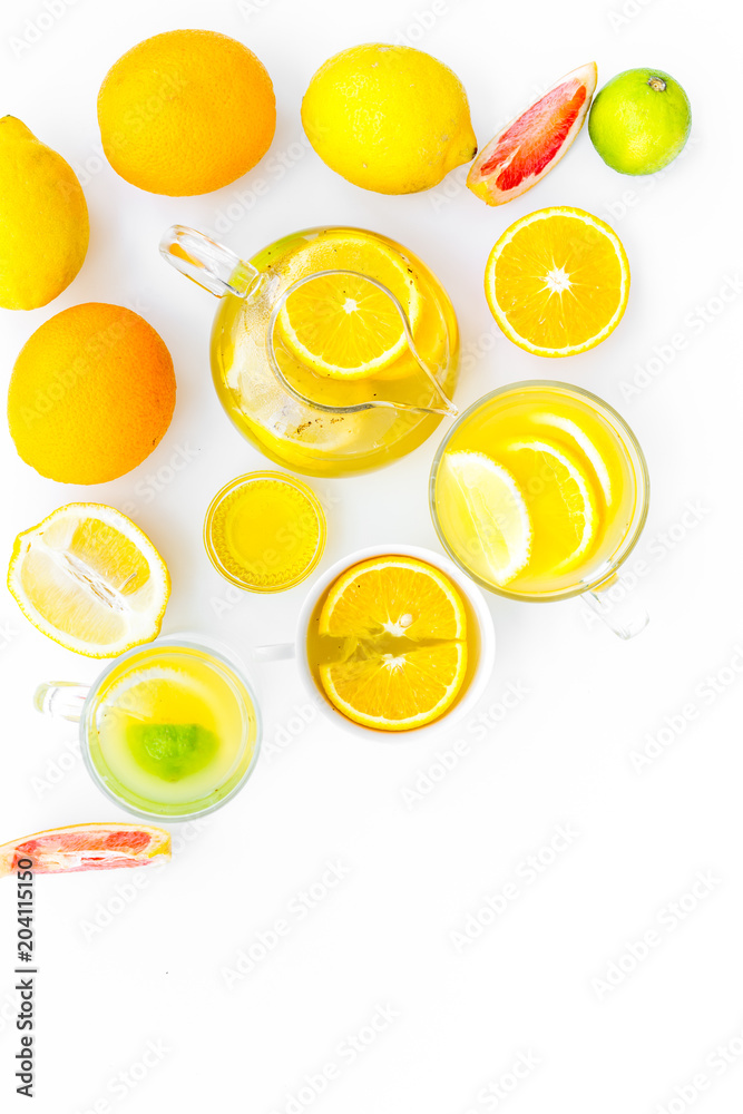 Fototapeta Fruit tea. Teacup and teapot among citrus on white background top view copy space
