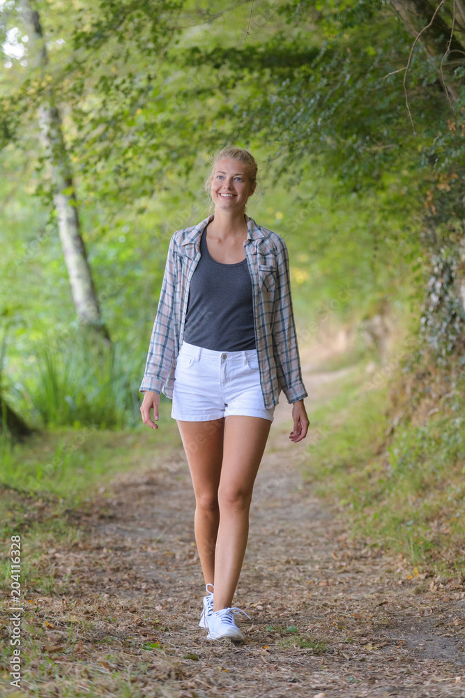 blond haired woman walking in the forest blond haired woman walking in the forest