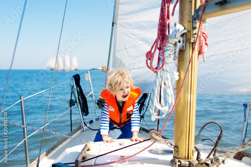 Kids sail on yacht in sea. Child sailing on boat. © famveldman
