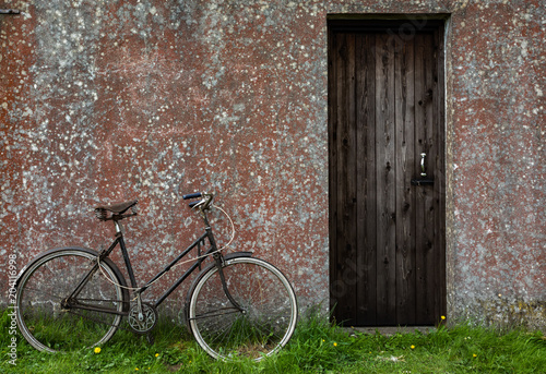 Old Vintage bicycle leaning against grungy stone wall shed