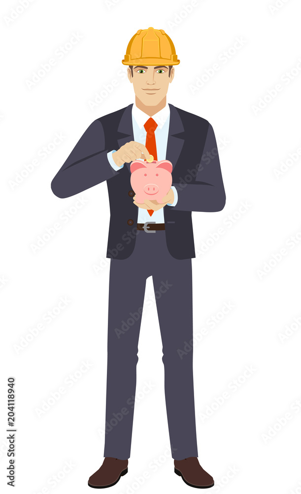 Businesswoman in construction helmet putting a coin into piggy bank
